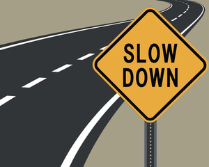 A yellow diamond-shaped road sign instructs drivers to "SLOW DOWN" next to a curving highway.