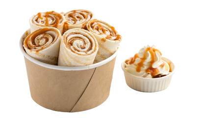Delicious caramel ice cream rolls served in a cup, paired with a side of whipped cream and caramel sauce, offering a sweet treat experience for dessert lovers