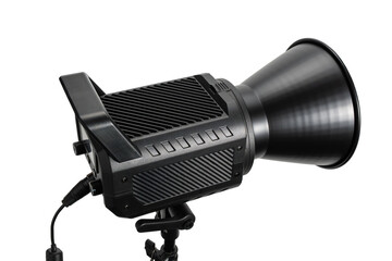 Angled side view of a studio light with deep reflector on a stand, isolated on white. Professional photography lighting equipment with handle, mount, and cable.