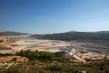 Panoramic aerial view of coal mine. Open pit mine industry, big yellow mining truck for coal quarry. Open coal mining anthracite mining. Pit on coal mining by open way. 