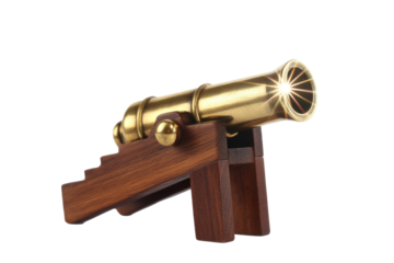 A miniature golden brass cannon on a dark wooden stand, featuring a striking starburst light effect from its barrel opening. background removed