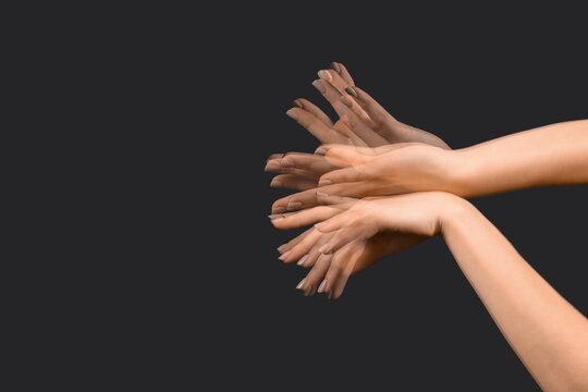 Stroboscopic photo of moving female hands on black background