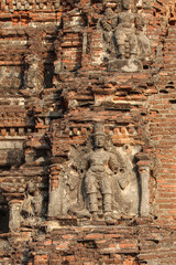 Weathered stone sculptures adorning an ancient brick temple in India