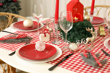 Festive Christmas dinner table setting with ornaments and fir branches, closeup