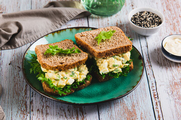 Eggs, avocado on lettuce leaves on toast on a plate on the table