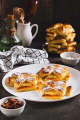 Sweet puff pastries with pineapple in powdered sugar on the table vertical view