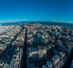 Fototapeta premium A vibrant aerial panorama of Bari, Italy, capturing the golden-hued Old Town and port alongside the modern city grid, stretching out to the deep blue Adriatic horizon.