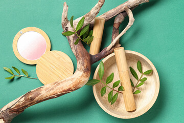 Beautiful composition with tree bark and decorative cosmetics on green background