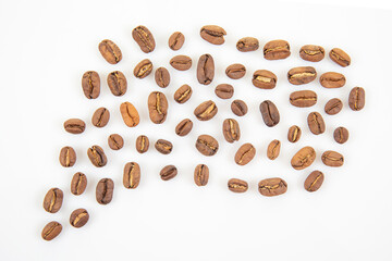 Naklejka premium Roasted coffee beans with earthy colors and visible textures spread across a white surface. Great for coffee shop marketing and culinary projects.