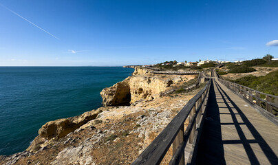 Fototapeta premium Carvoeiro boardwalk along the cliffs at sunset. Carvoeiro, Portugal. November 30, 2025