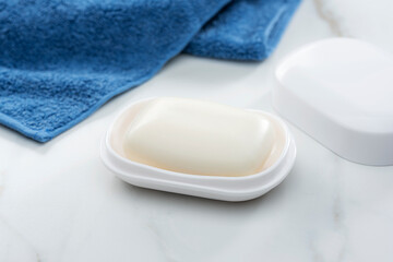 泡の乗った固形石けんとタオルが並ぶ清潔感あふれるバスルームイメージとコピースペース