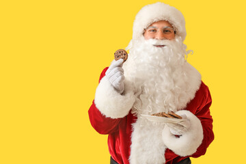 Santa Claus with cookies on yellow background