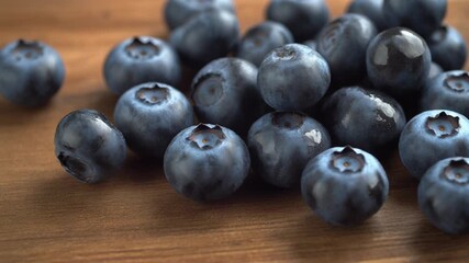Plump blueberries gleaming on wooden table, a dynamic close-up inviting healthy eating and vibrant recipes for a balanced lifestyle