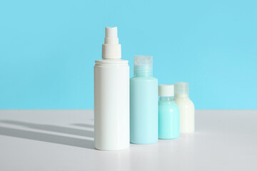 Travel cosmetic kit on light table against color background