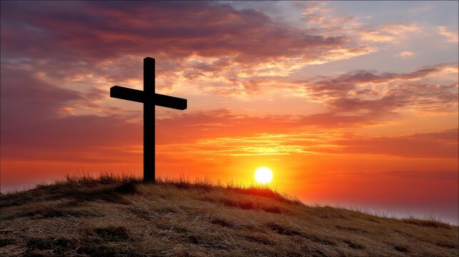 A simple wooden cross stands atop a grassy hill, silhouetted against a vibrant sunrise. 