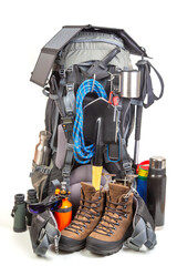 Items for tourism and hiking near a tourist backpack on a white background. set of equipment for tourism and travel