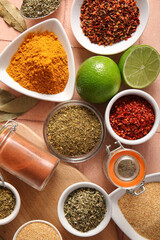Composition with different aromatic spices and lime on color tile table