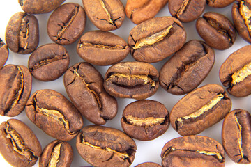 High-resolution image of roasted coffee beans, emphasizing their natural texture and warm brown shades on a white surface. Suitable for caffeine-themed designs.
