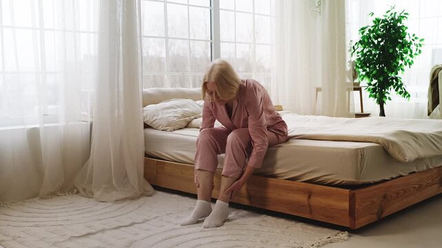 Senior woman massaging swollen painful legs, suffering varicose veins