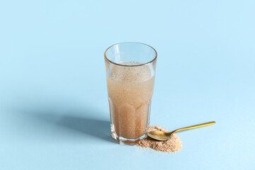 Glass of water with psyllium husk on light blue background