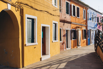 Burano Island street with colorful houses and sunlight