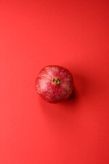 A juicy, ripe, whole red pomegranate as a source of beneficial nutrients. A whole red pomegranate