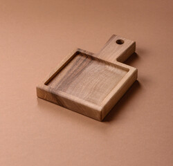 Wood, a wooden empty cutting board on a dark kitchen table. Wooden cutting board