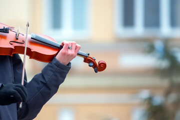 Street musician playing the violin. Musical creativity. Bowed stringed musical instrument