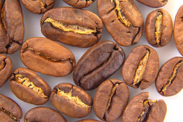 Vibrant macro image of roasted coffee beans, revealing their intricate textures and deep brown colors on a white backdrop. Ideal for gourmet food photography.
