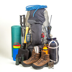 Items for tourism and hiking near a tourist backpack on a white background. set of equipment for tourism and travel