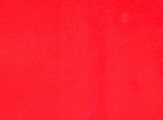 Red wall, background, texture. Smooth but a little shabby surface. Reddish plastic surface, backdrop. Red-colored plastic (polystyrene) covering. Old, worn out, shabby, plastic surface of deep red