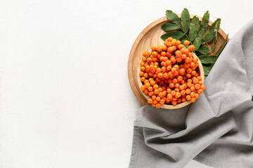 Composition with tray and branches of ripe rowan berries on white grunge background