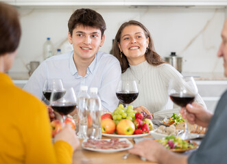 Happy family having dinner together at the festive table at home
