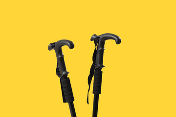 Walking poles on yellow background, closeup