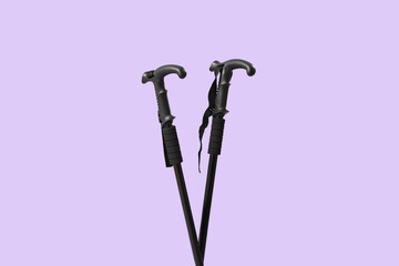 Walking poles on lilac background