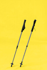 Walking poles on yellow background