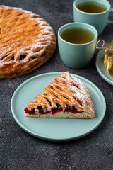 A tempting slice of pie, filled with fruity goodness, rests on a soft plate next to delicate tea cups. Freshly baked pie radiates warmth, creating a cozy atmosphere perfect for sharing