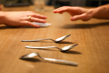People playing the card game Spoons. The popular game is fun for family gatherings and game night on a kitchen table. It is a competition and gambling opportunity for friends on holidays. 