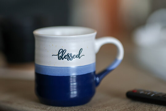 Ceramic coffee mug with the word Blessed over blue color. 