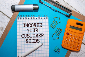 uncover your customer needs. Text on white paper in hand