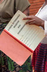 Lilongwe Malawi Africa. 10.11.2025.  Teachers hand holding  a school attendance register  and performance record book.