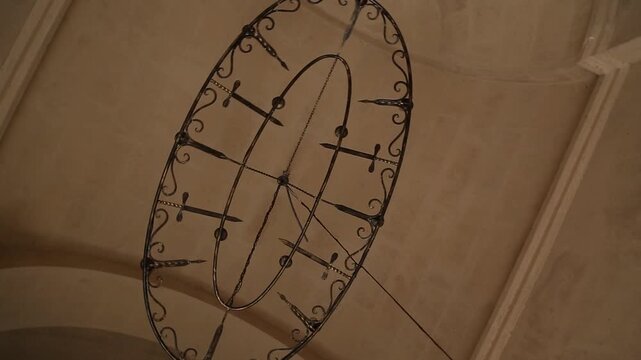 interior view of a stone church featuring a painting of Jesus Christ on the wall. Below stands a stone baptismal font and a red ceremonial stand.