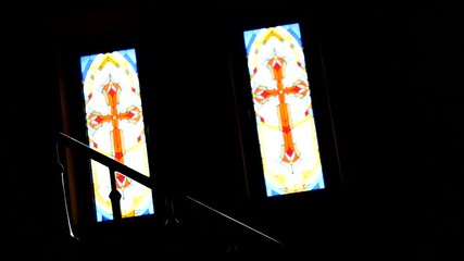 interior view of a stone church featuring a painting of Jesus Christ on the wall. Below stands a stone baptismal font and a red ceremonial stand.