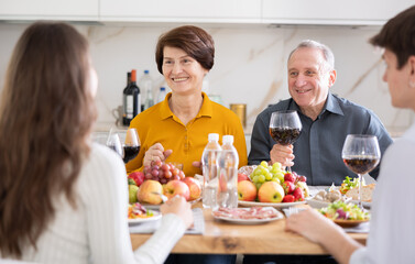 Happy family having dinner together at the festive table at home
