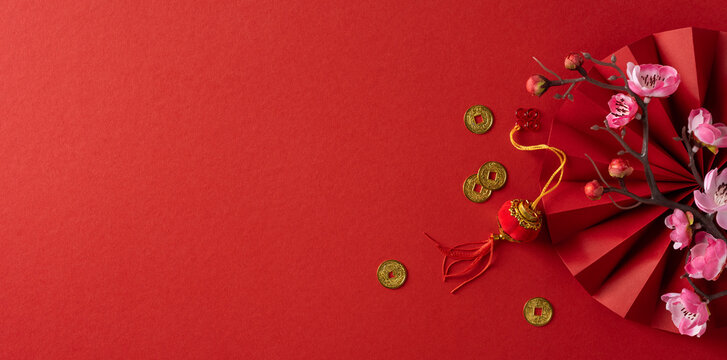 Vibrant banner red background features a decorative fan with pink bloom and gold coin accents, conveying festive luck and prosperity for Chinese New Year