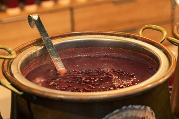 Hot cranberry jelly drink in a big pot in a Christmas market