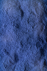 Fine indigo powder lies across a textured background, displaying a deep, vivid color that suggests artistic potential. The soft grains catch light, inviting creativity © Tkachenko Alexey