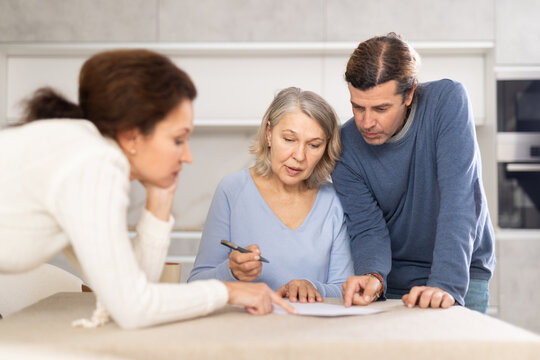 Man and woman help elderly mother make will and fill out document correctly. Family advice, help and support