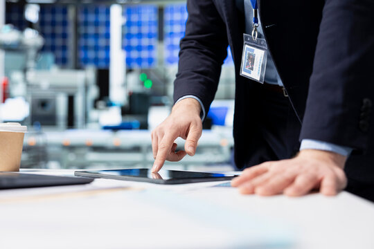 Operations employee checking performance data in a solar panel facility, showcasing dedication to workplace efficiency and working on green energy manufacturing and engineering.