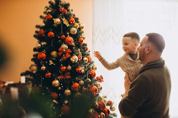 Father and son enjoying christmas tree decoration